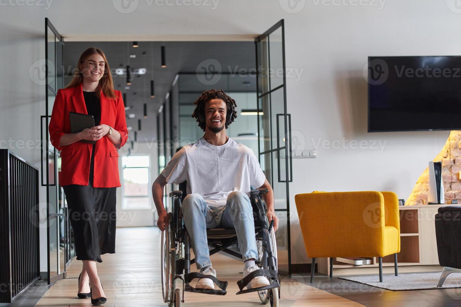 A group of young business people in a modern glass-walled office captures the essence of diversity and collaboration, while two colleagues, including an African American businessman in a wheelchair photo