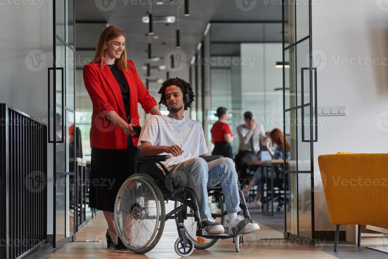 A group of young business people in a modern glass-walled office captures the essence of diversity and collaboration, while two colleagues, including an African American businessman in a wheelchair photo