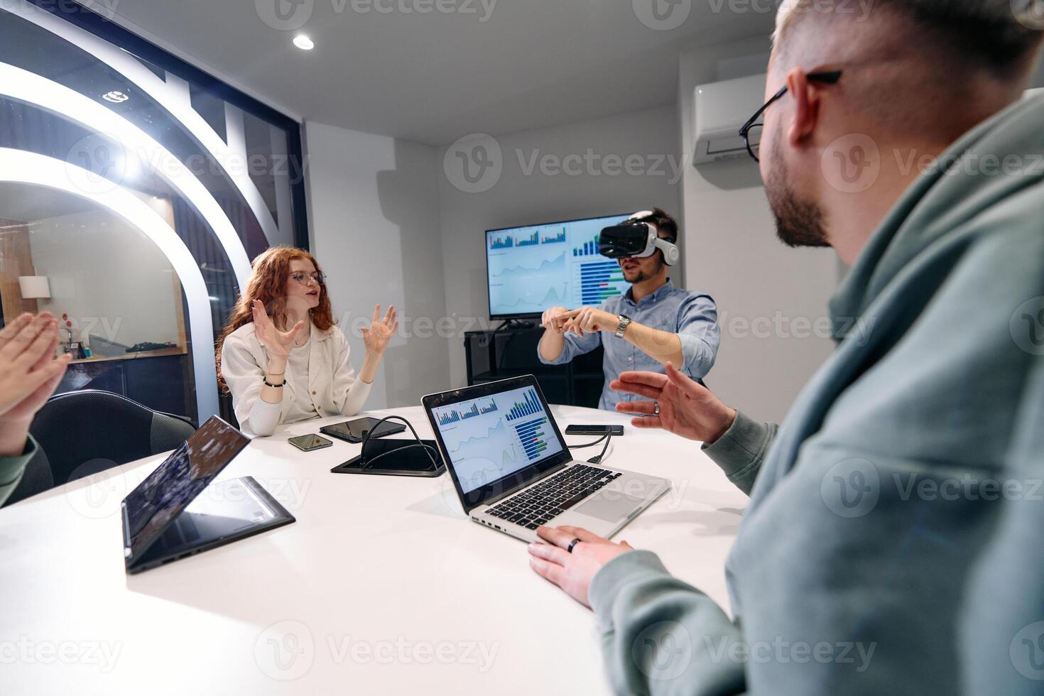 A diverse group of businessmen collaborates and tests a new virtual reality technology, wearing virtual glasses, showcasing innovation and creativity in their futuristic workspace photo