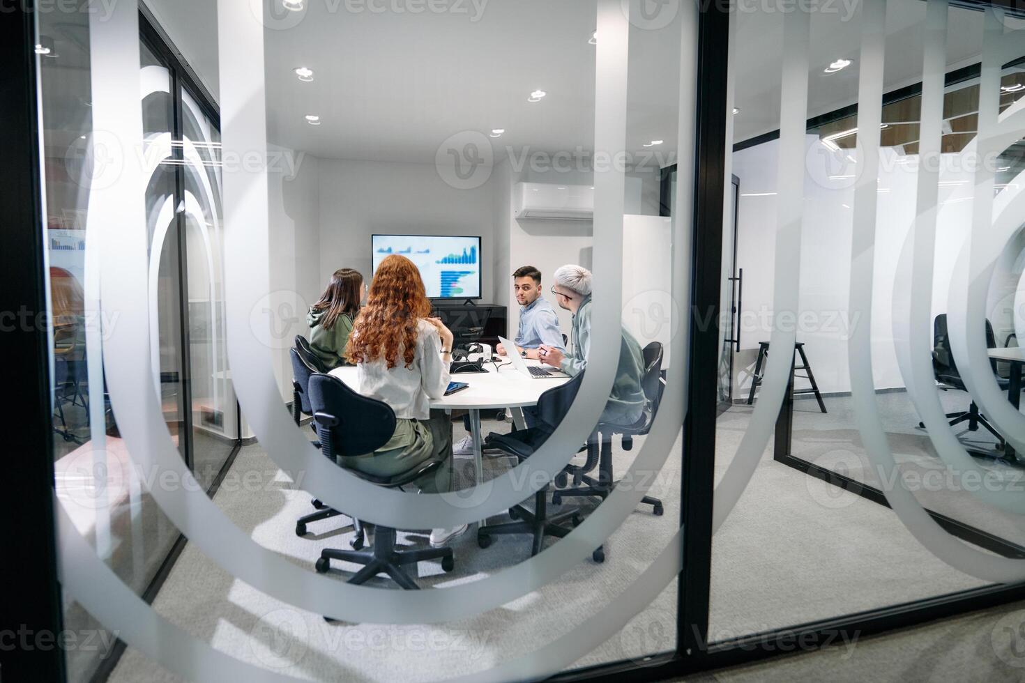 A diverse group of businessmen collaborates and tests a new virtual reality technology, wearing virtual glasses, showcasing innovation and creativity in their futuristic workspace photo