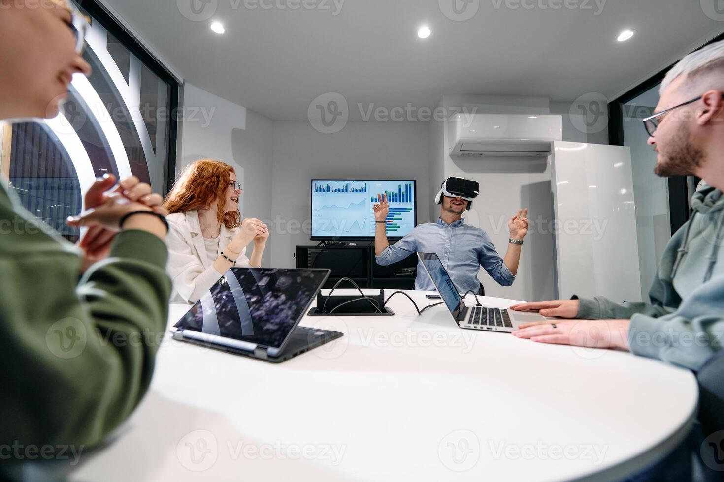 A diverse group of businessmen collaborates and tests a new virtual reality technology, wearing virtual glasses, showcasing innovation and creativity in their futuristic workspace photo