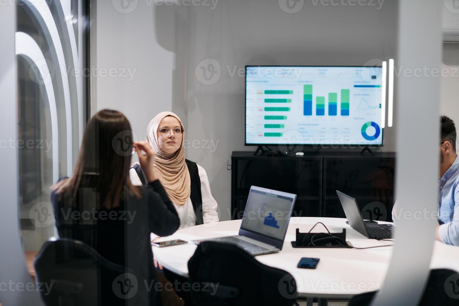 A diverse group of businessmen collaborates and tests a new virtual reality technology, wearing virtual glasses, showcasing innovation and creativity in their futuristic workspace photo