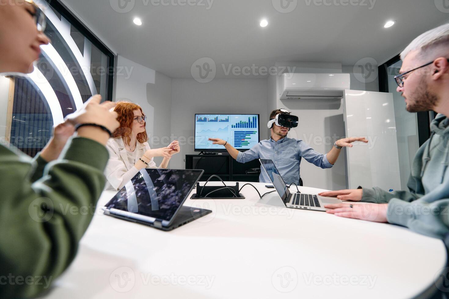 A diverse group of businessmen collaborates and tests a new virtual reality technology, wearing virtual glasses, showcasing innovation and creativity in their futuristic workspace photo
