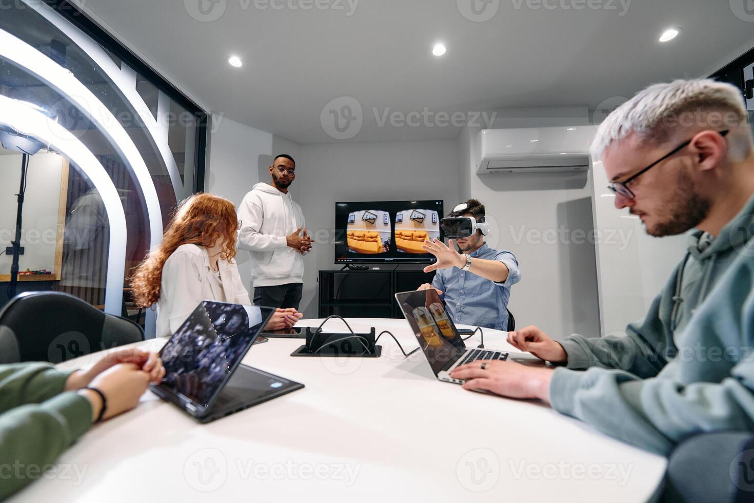 A diverse group of businessmen collaborates and tests a new virtual reality technology, wearing virtual glasses, showcasing innovation and creativity in their futuristic workspace photo