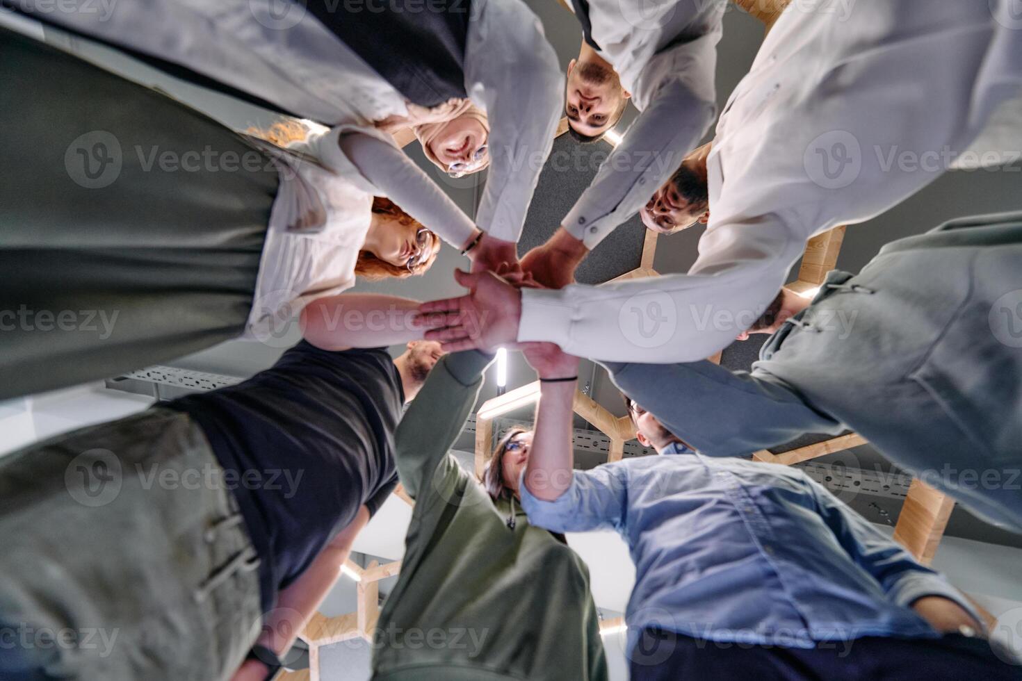A group of young businessmen offer their hands together, symbolizing togetherness in the business world photo
