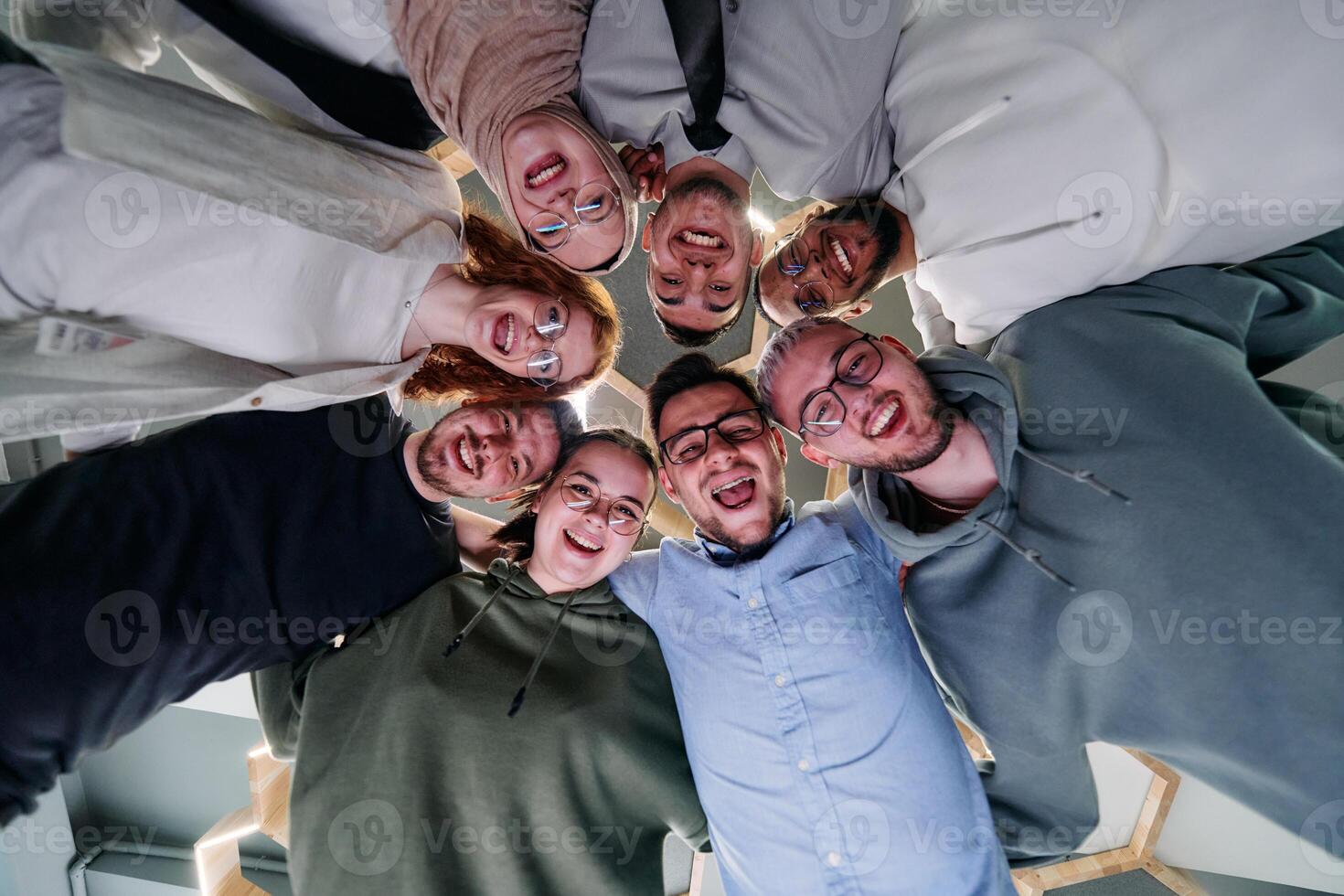 In a modern office, a group of young business professionals is captured in a warm and embracing hug, reflecting the spirit of unity, collaboration, and shared success in their dynamic workplace. photo