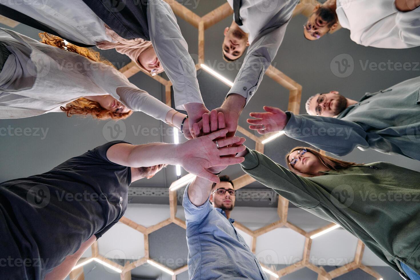 A group of young businessmen offer their hands together, symbolizing togetherness in the business world photo