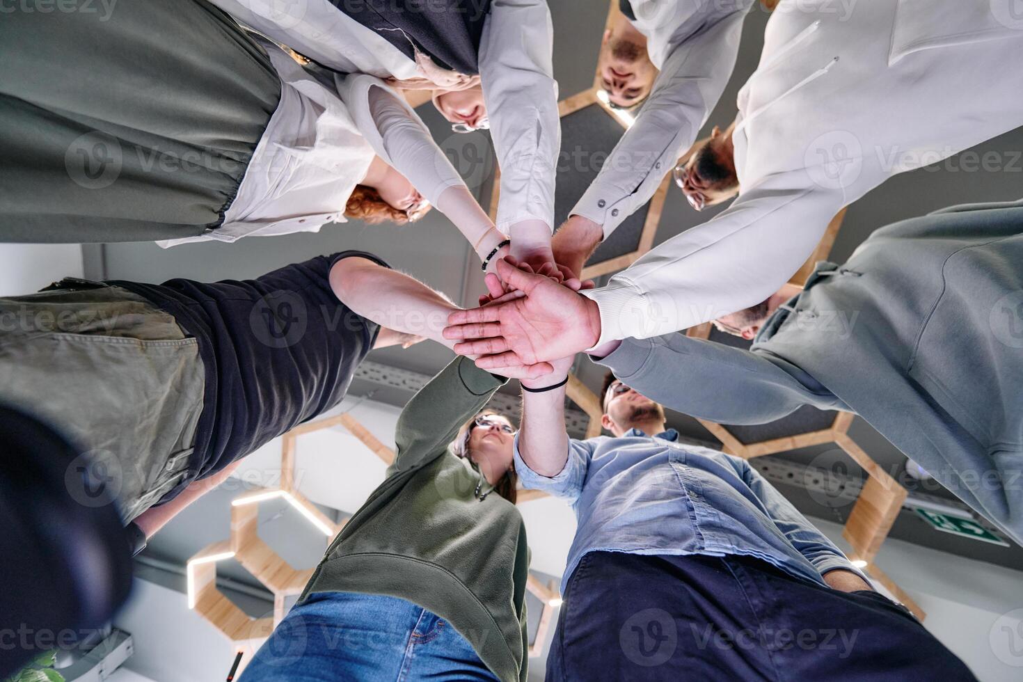 A group of young businessmen offer their hands together, symbolizing togetherness in the business world photo