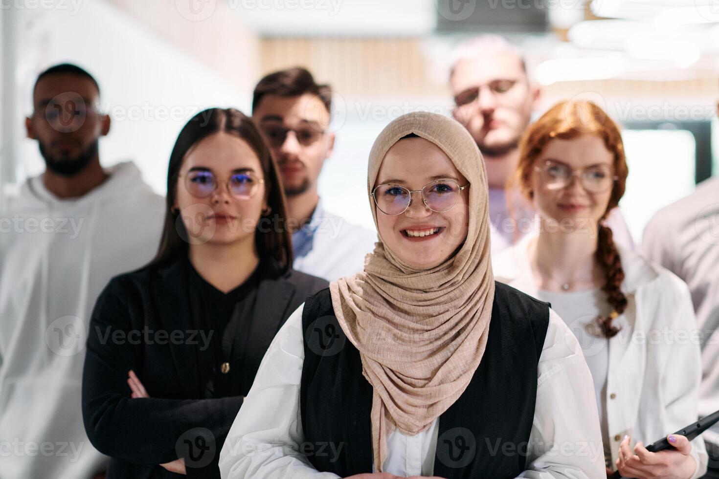 A group of business professionals standing together, taking a well-deserved break from their busy workday, showcasing camaraderie, teamwork, and a moment of relaxation in their dynamic workplace photo