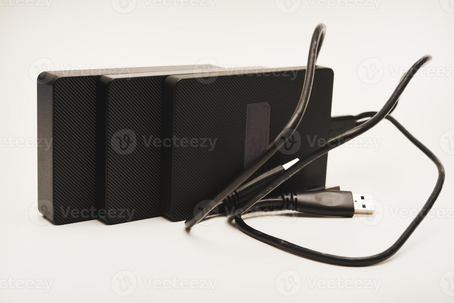 Hard drives a white background. Modern data storage devices with USB wires. photo