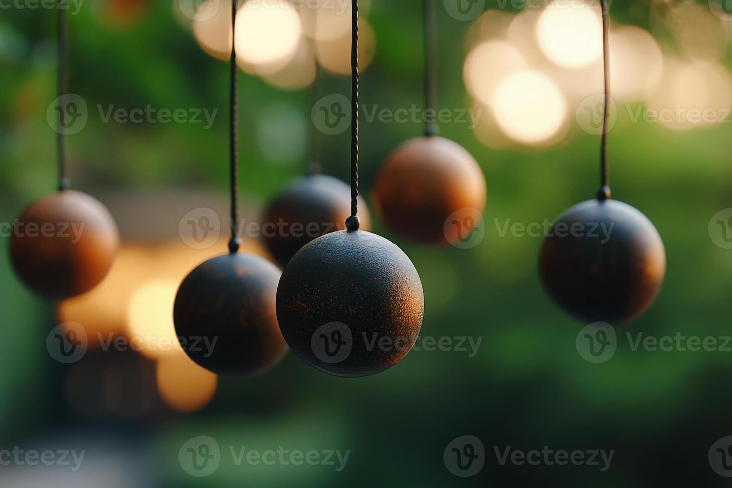 Decorative wooden spheres suspended in a tranquil garden during golden hour with blurred background lights photo