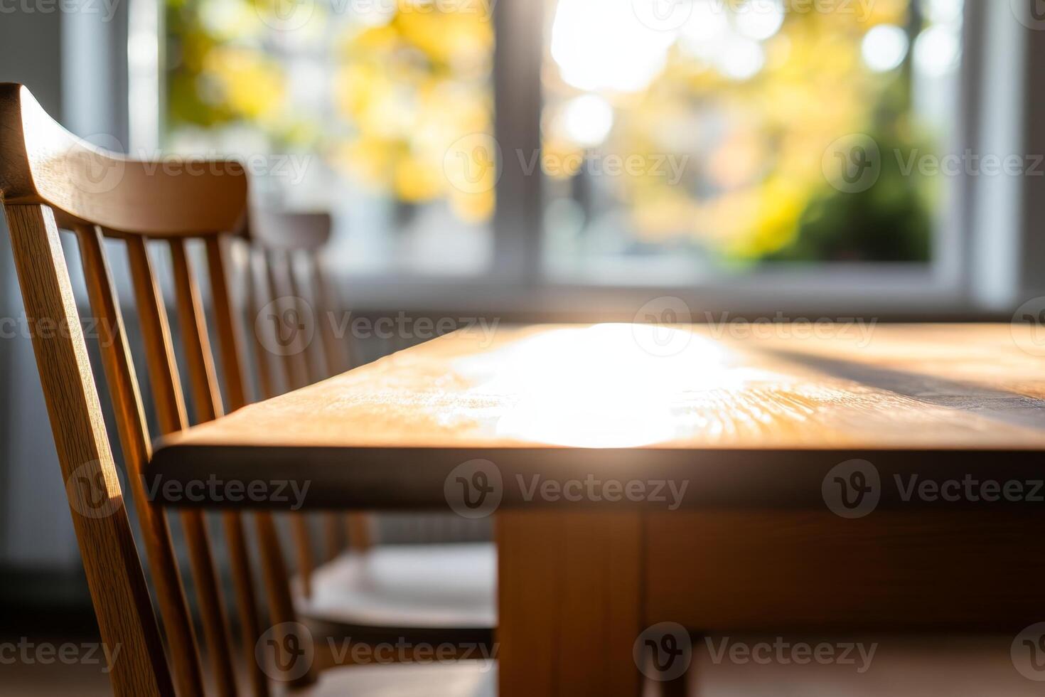 Warm sunlight illuminates a wooden table and chair in a cozy interior setting photo