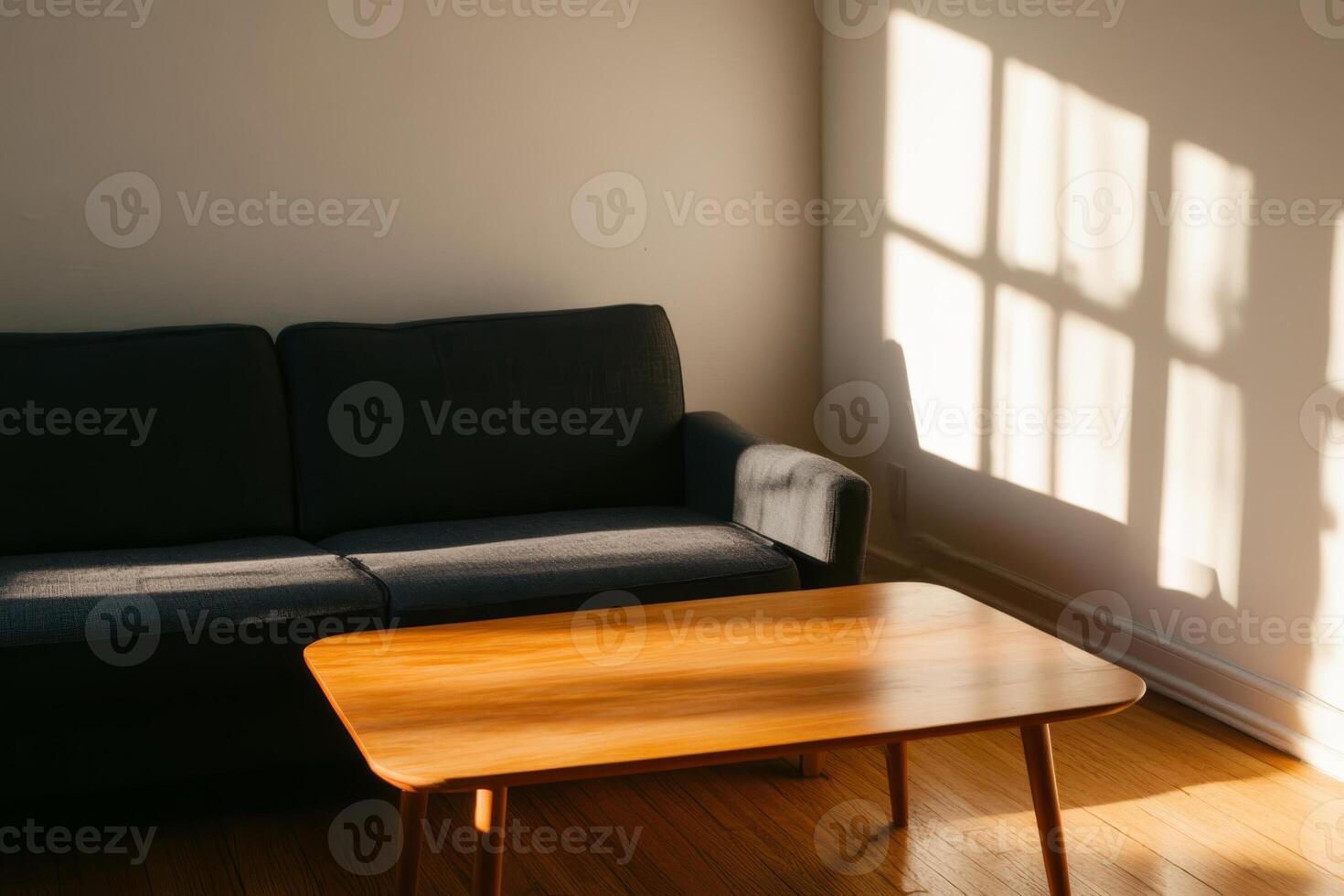 Cozy living room with sunlight casting shadows on a wooden table and dark sofa during afternoon hours photo