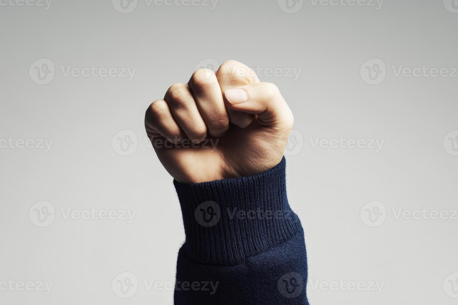 Fist raised in solidarity against a neutral background during an empowerment event or campaign photo