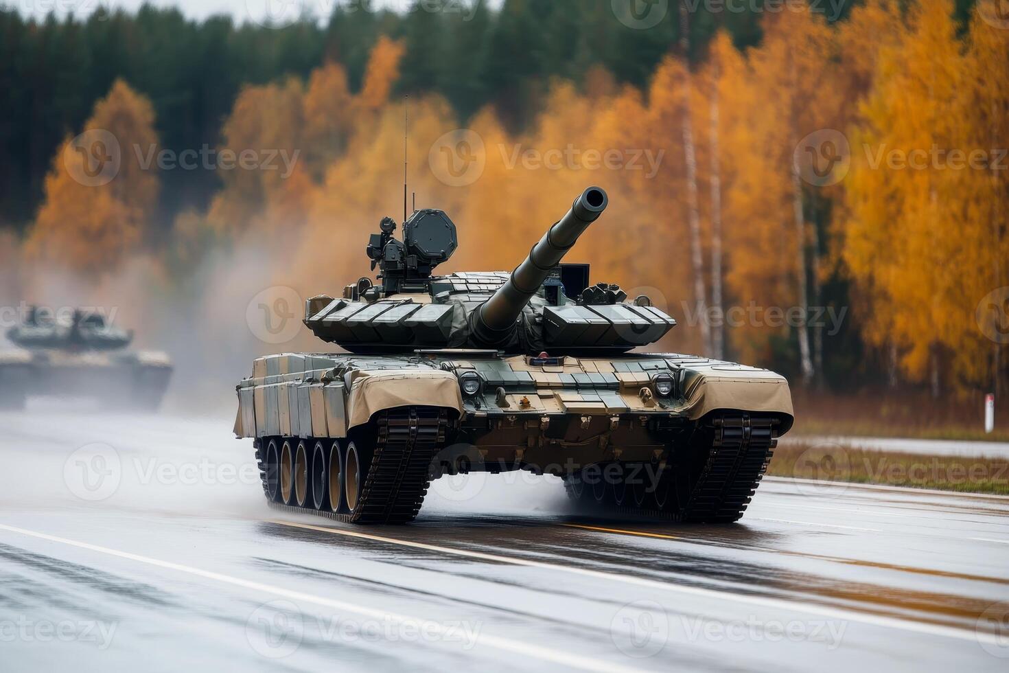 Military tanks maneuvering on a wet road surrounded by autumn trees in a training exercise photo