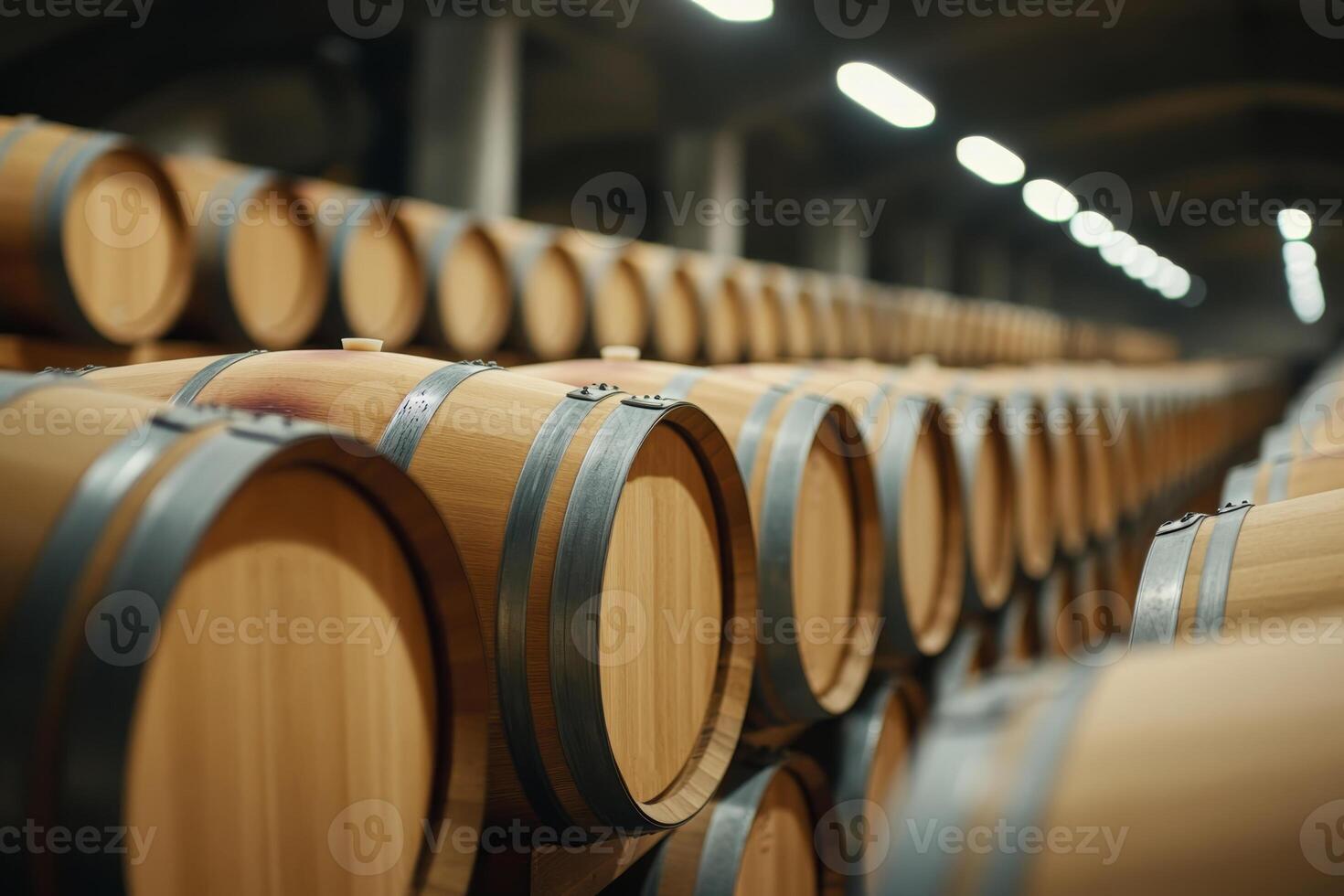 Rows of oak barrels in a dimly lit winery showcasing the aging process of wine photo