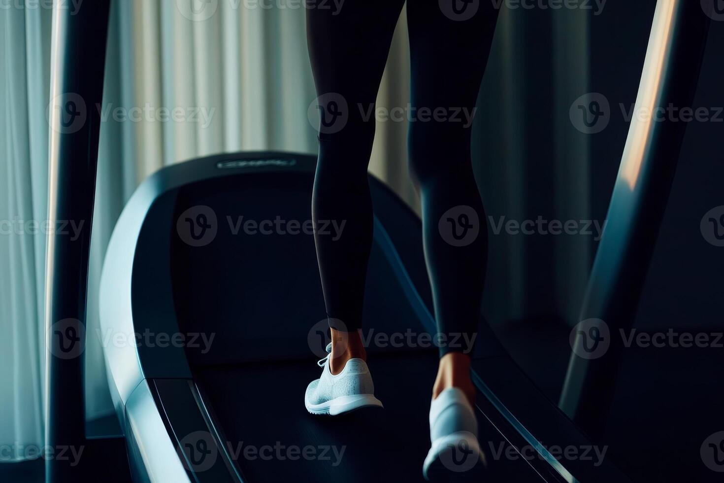 Person walking on a treadmill in a dimly lit indoor gym space, focused on fitness and health activities photo