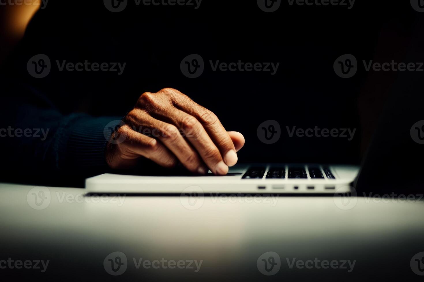 Hands typing on a laptop in low light, creating a focused atmosphere for work or research tasks photo
