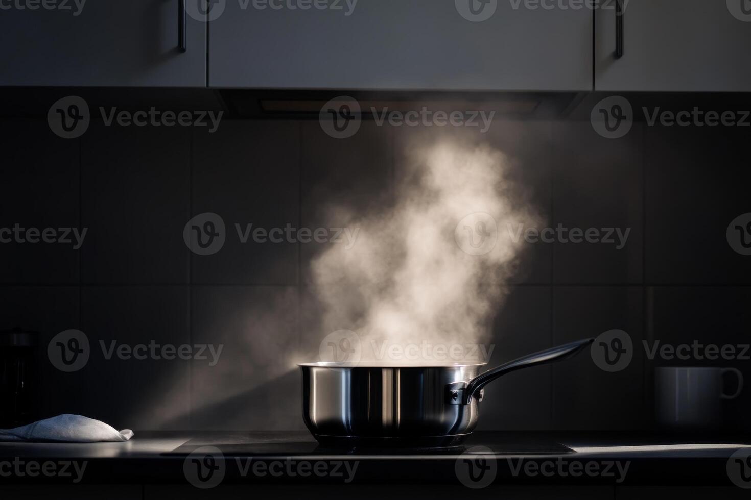 Steam rises from a pot on the stove in a modern kitchen during evening cooking photo