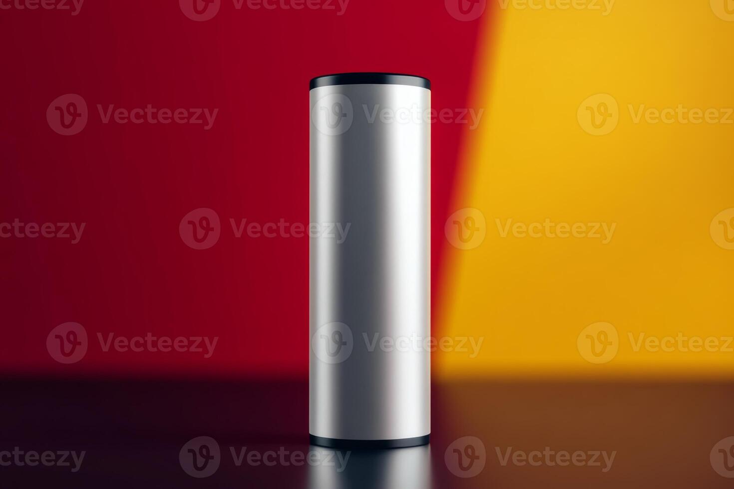 Metal cylindrical object placed on a dark surface with contrasting red and yellow backgrounds photo