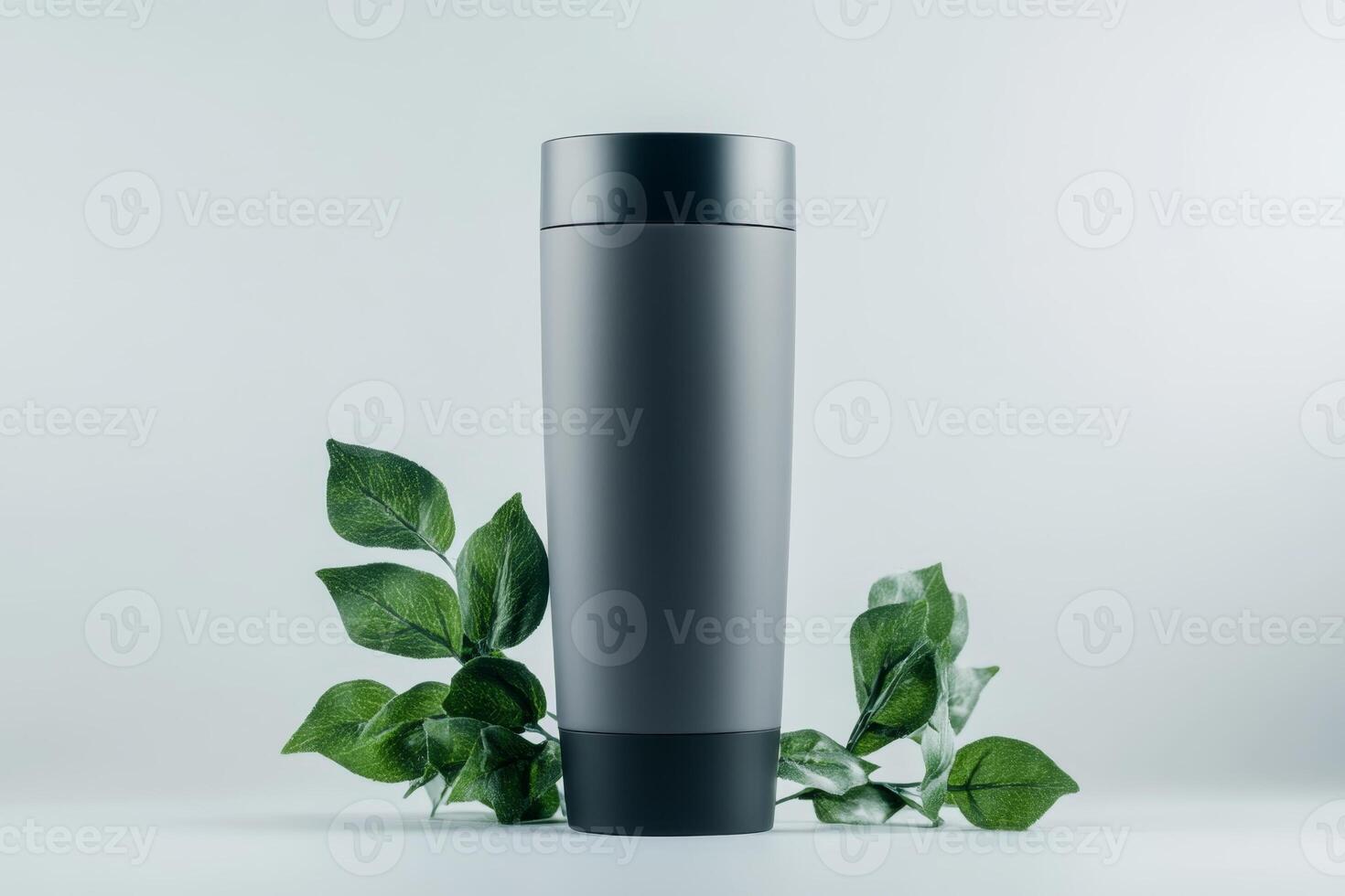 Modern stainless steel tumbler stands among green leaves on a light background showcasing eco-friendly design photo