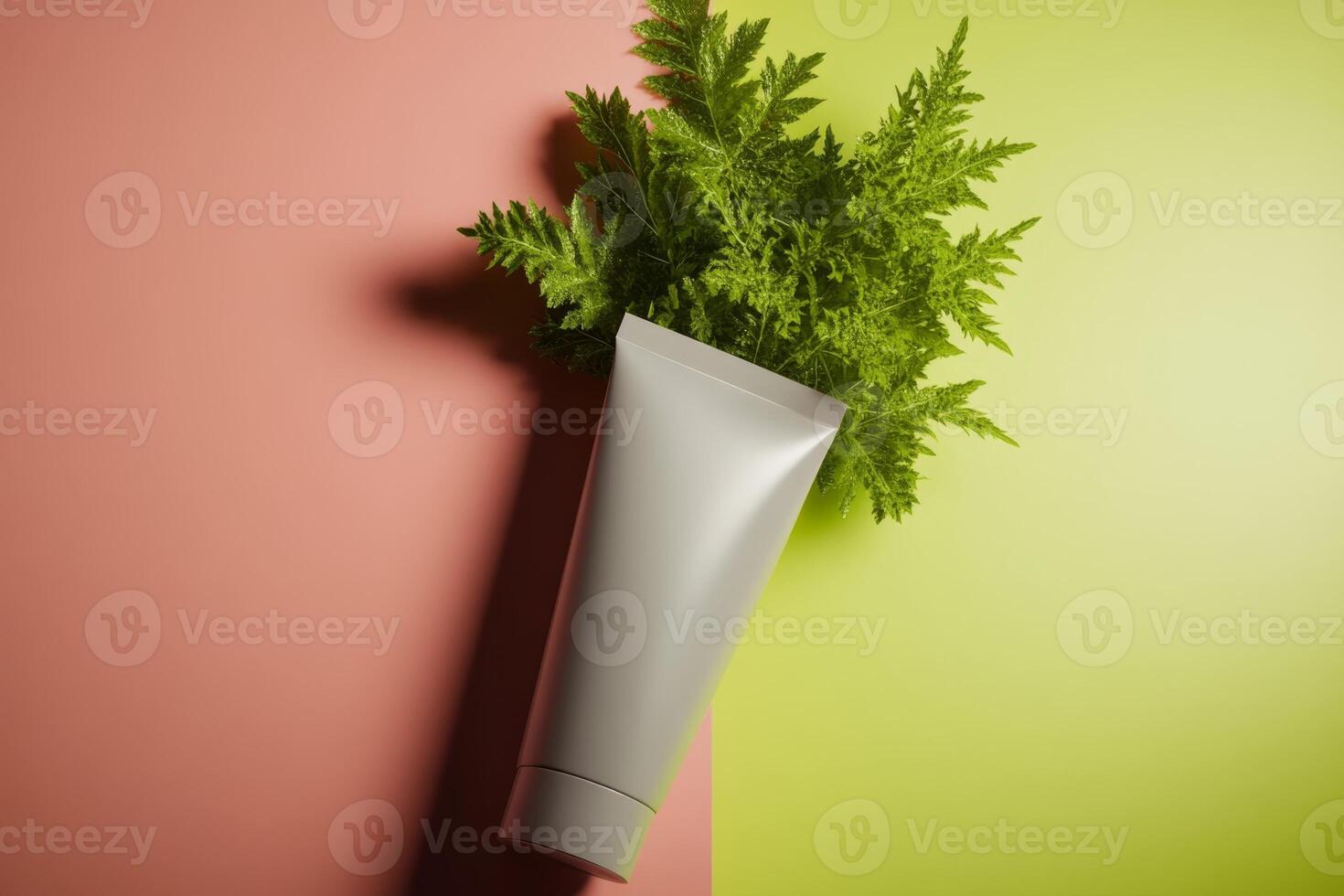 Creative arrangement of a tube and fresh green leaves on contrasting colorful background photo