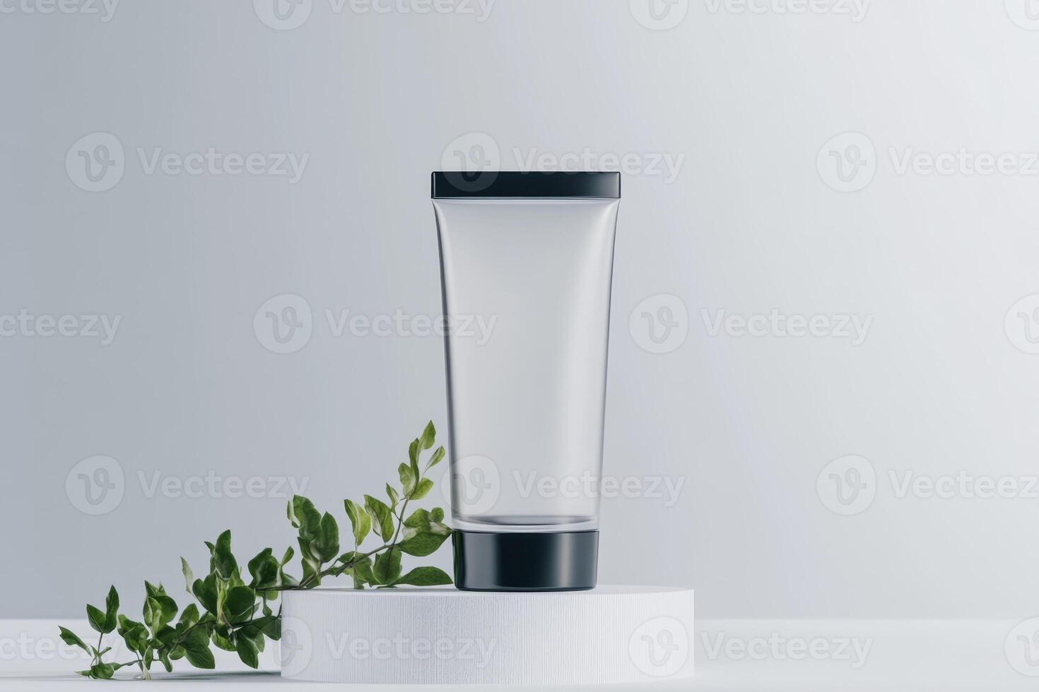 Clear glass container placed on a white pedestal with green foliage beside it in a minimalist setting photo