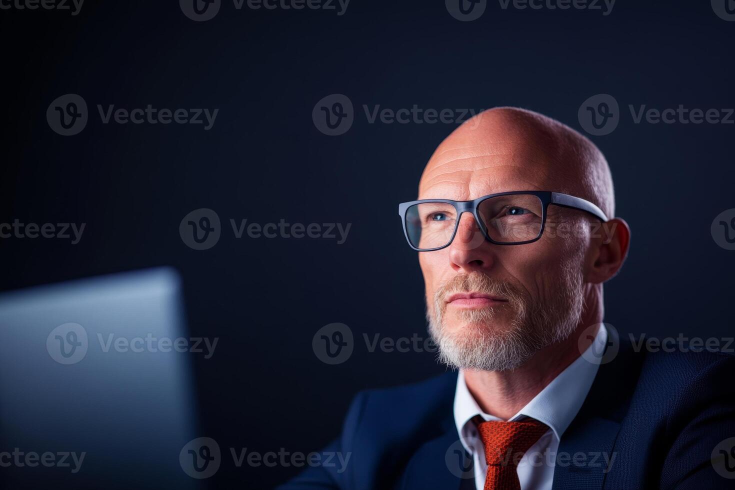 Thoughtful business professional focusing on work in a dark office setting during evening hours photo