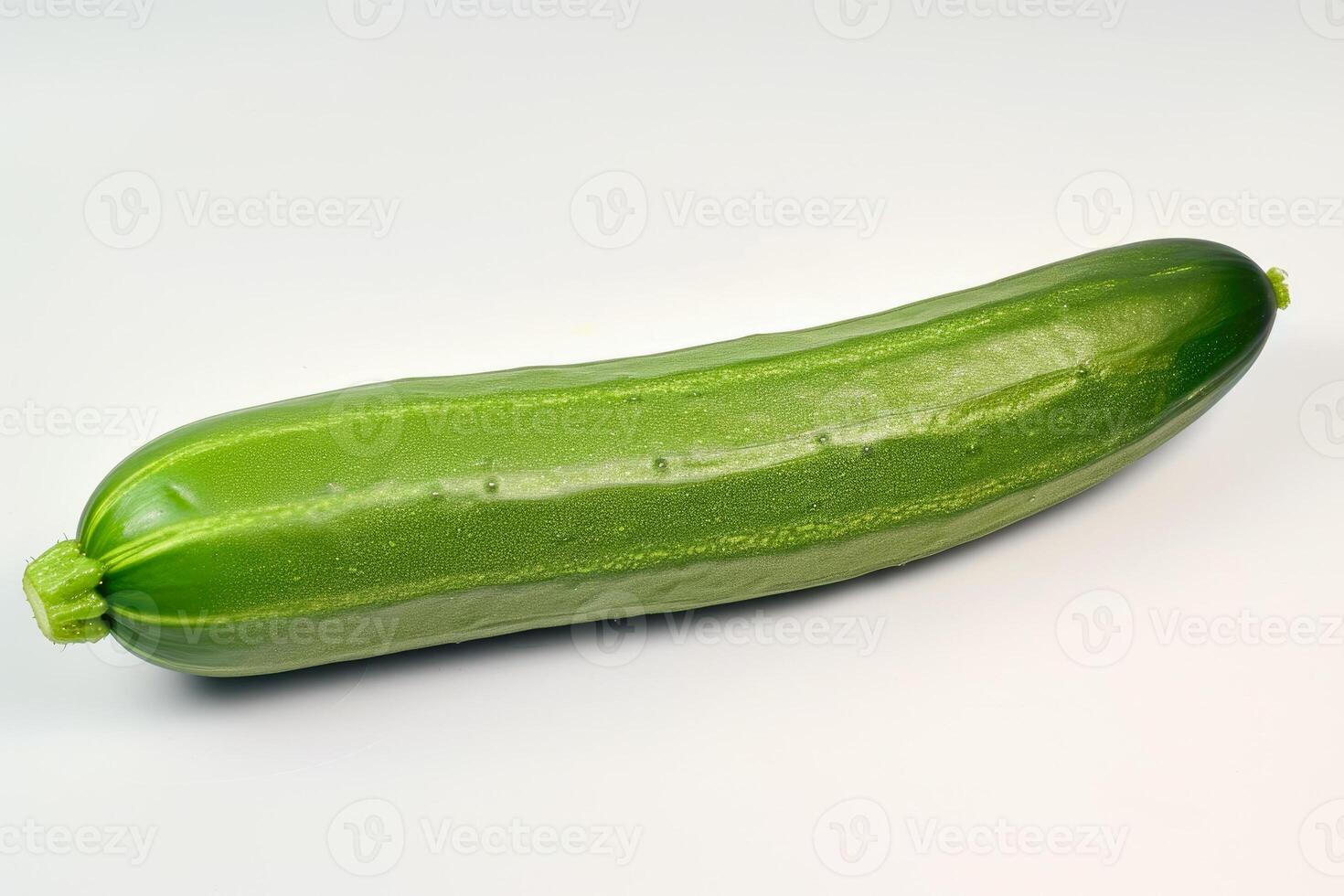 A cucumber is shown on a white surface photo