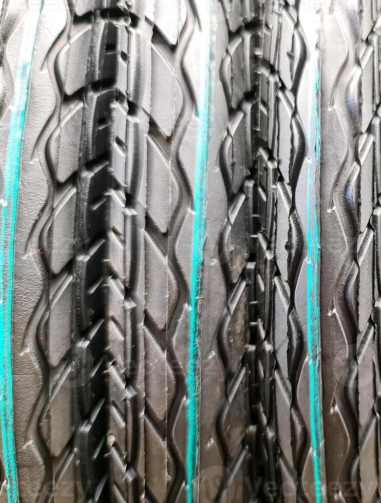 Close-up of stacked truck tires showing tread pattern and teal sidewall markings photo