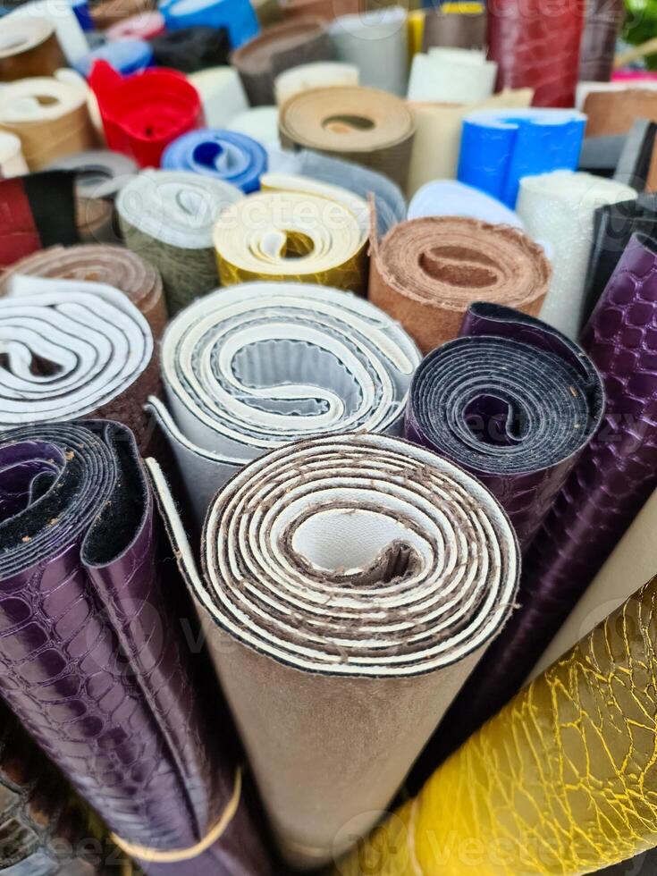 Colorful leather and fabric rolls forming a textured background photo