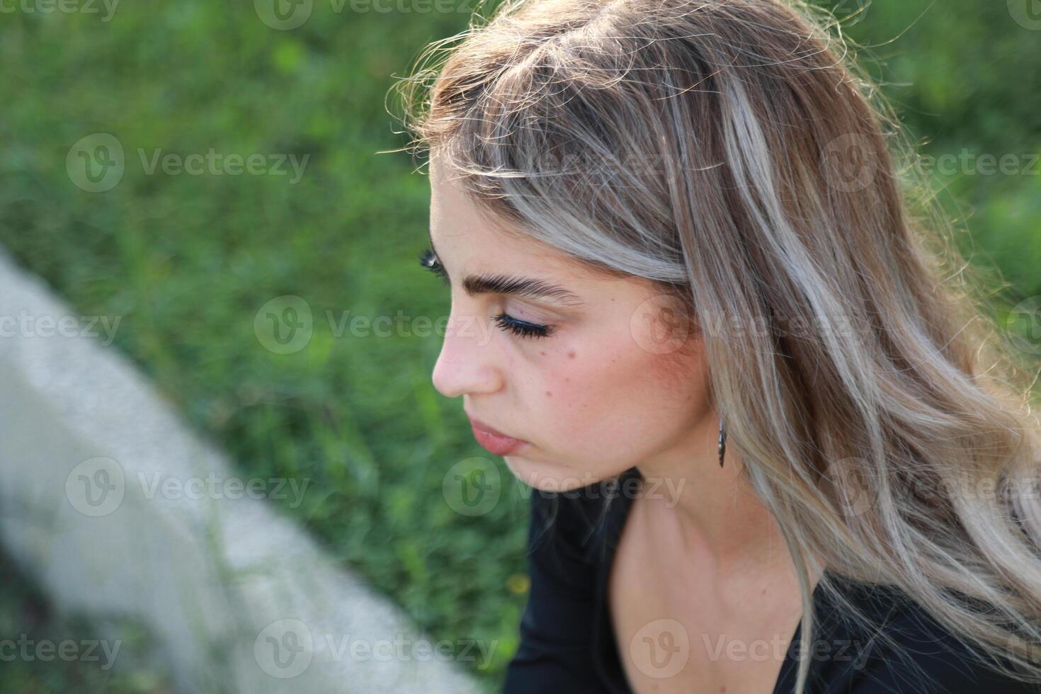 Contemplative Woman Sits Under a Shady Tree photo