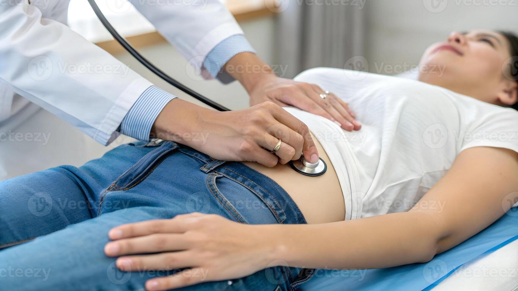Close-up of a doctor examining a patient's abdomen with a stethoscope, focusing on healthcare, diagnosis, and routine checkup in a clinical setting. photo