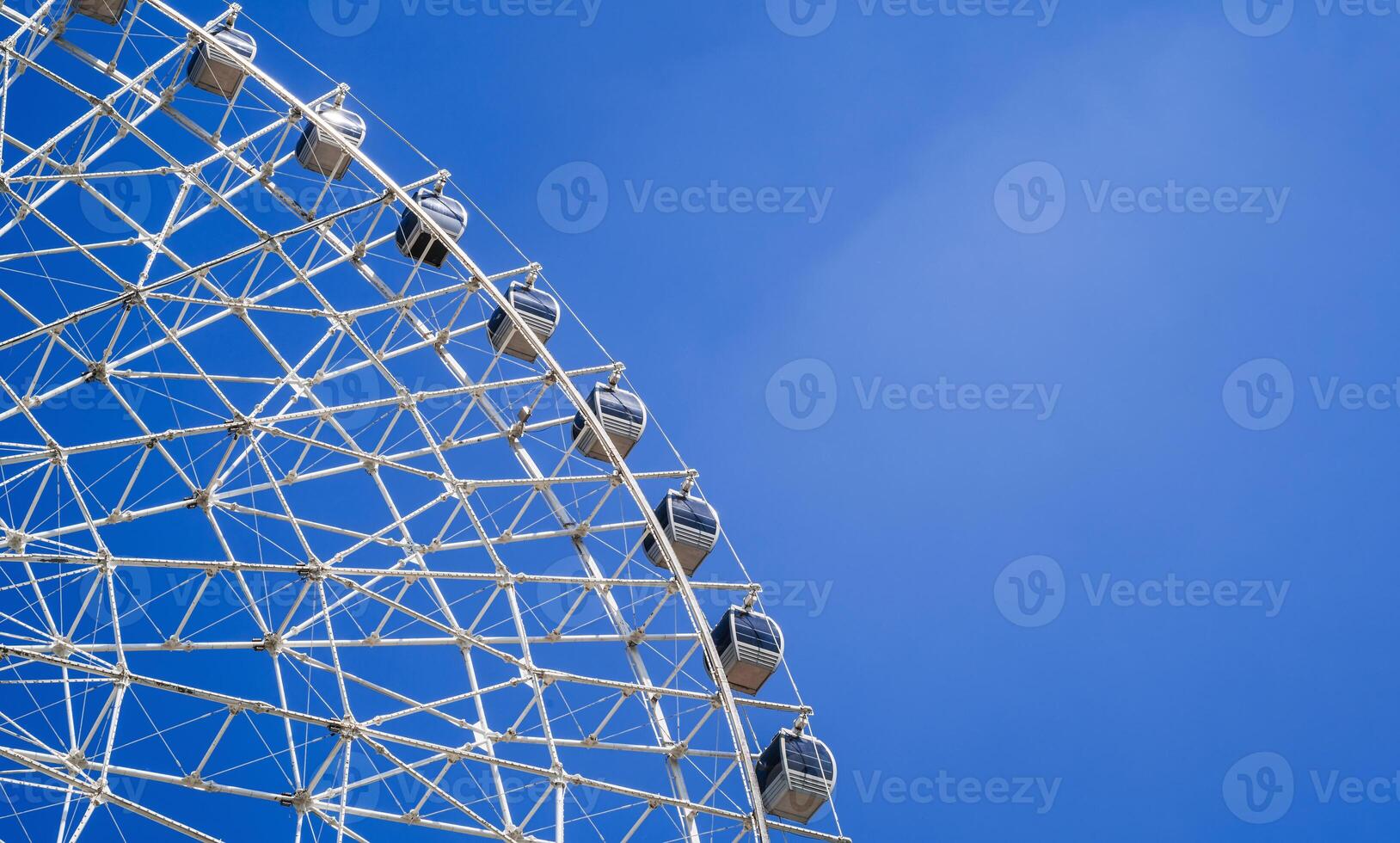 white Ferris wheel on background a bright blue sky in amusement park in summer with copy space photo