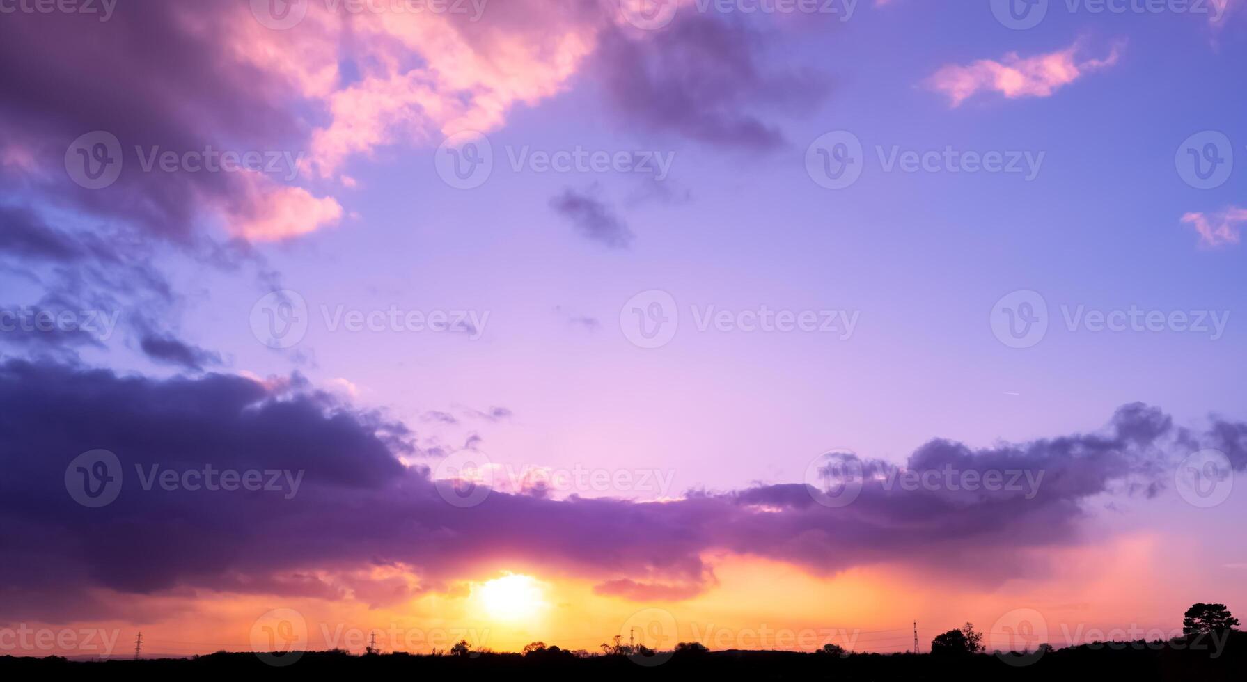 Sunset Sky background,Dramatic clouds, colourful twilight sky in purple, pink, blue, yellow, orange sky in evening Winter.Nature background golden hour of dusk sky and silhouette mount, forest trees photo