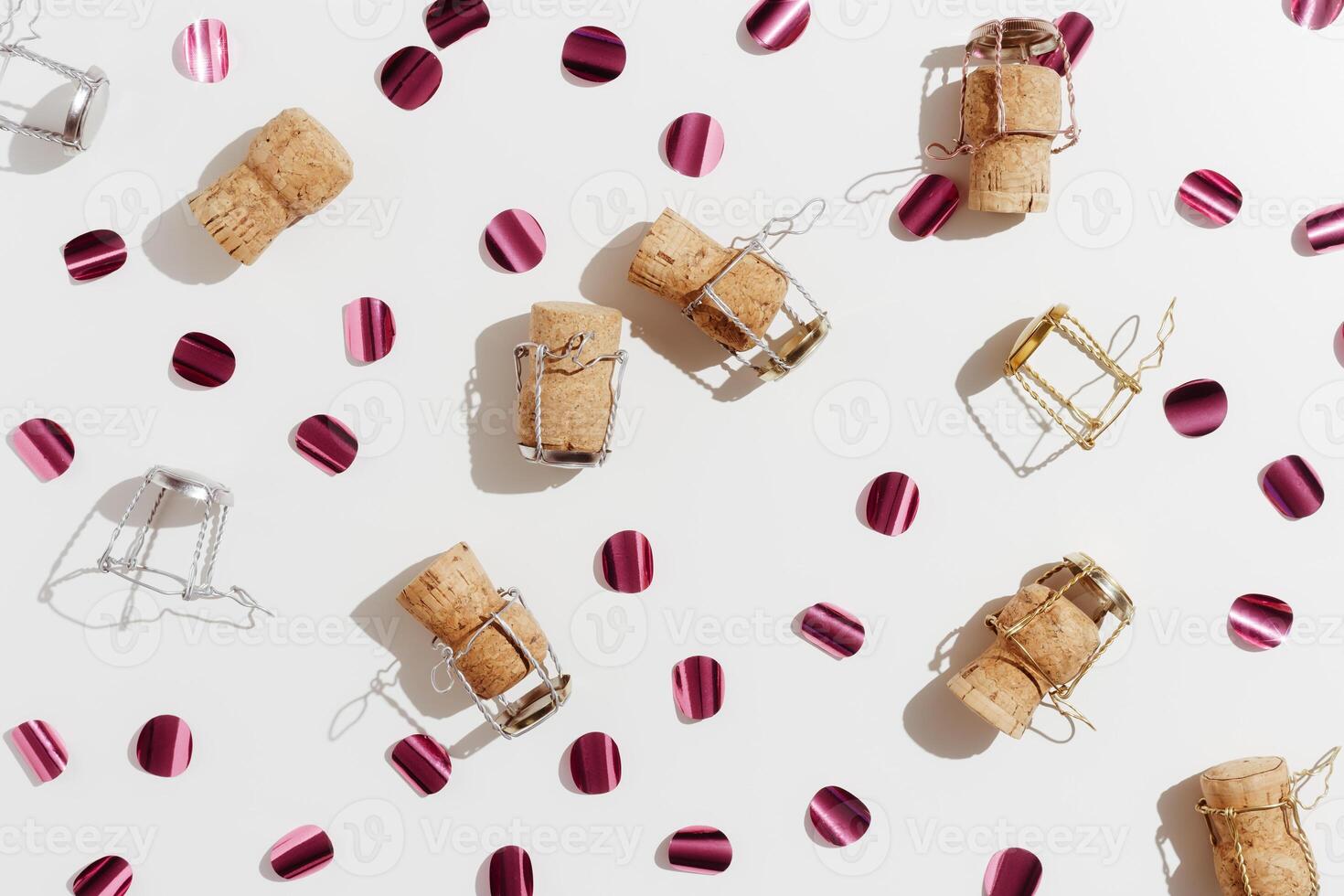 Champagne corks and sparkling confetti, top view composition, holidays, celebration concept. Wooden cork and muselet on pastel background at sunlight shadows. Flat lay festive minimal pattern photo