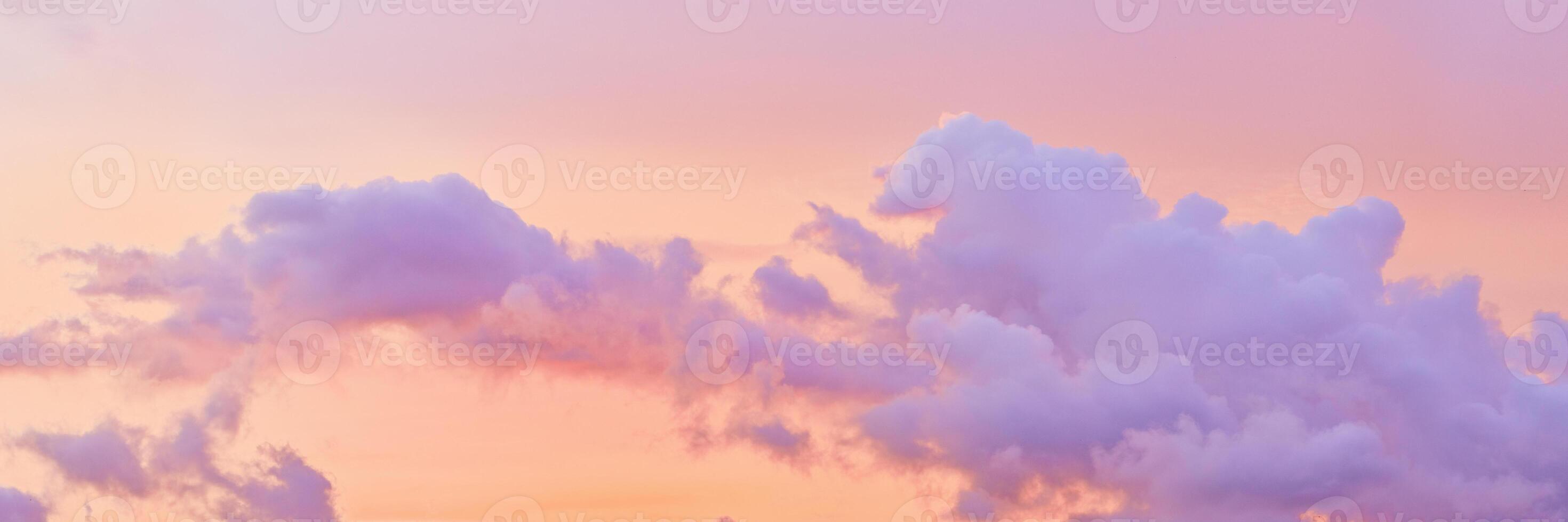 Aesthetic Pastel Sunset, violet fluffy clouds on pink peach colored sky, dreamy cloudscape pastel tones, surreal dreamscape at sunset, soft colorful heaven, wide banner, panoramic view. photo