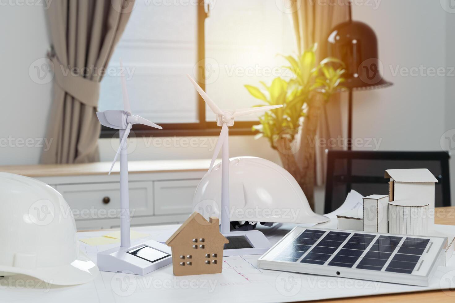 Engineer with wind turbine model sitting at desk in office. Wind turbine model, construction plan. photo