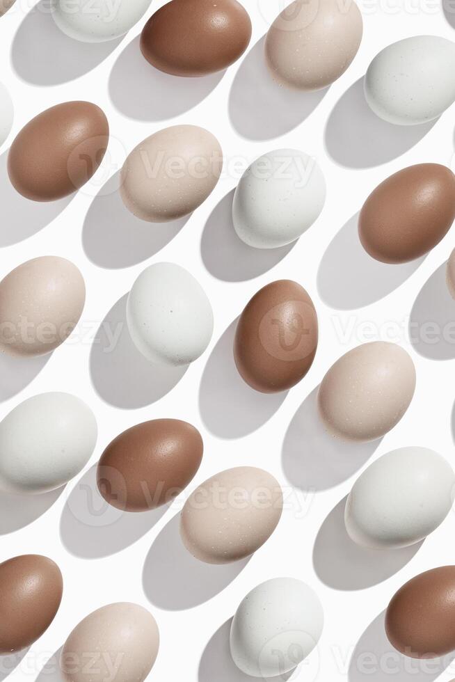 Pattern of Brown and beige Eggs with sun shadows, minimal style aesthetic holiday background, natural organic chicken eggs, breakfast ingredients, minimalist food composition, neutral pastel color photo
