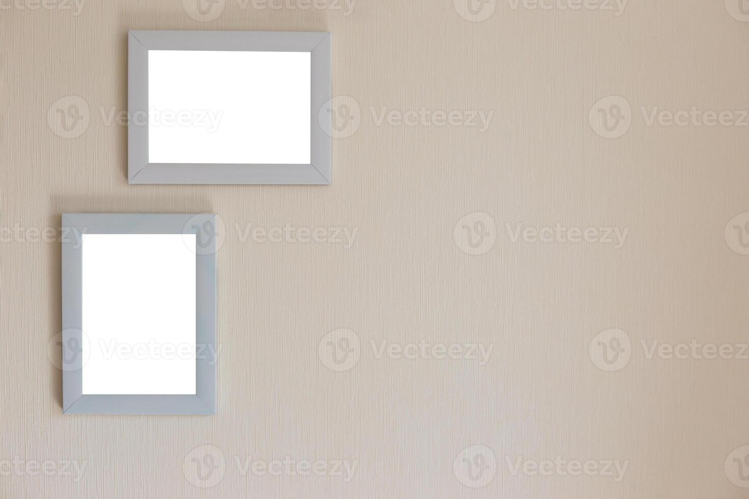 Two white frames on a beige wall photo