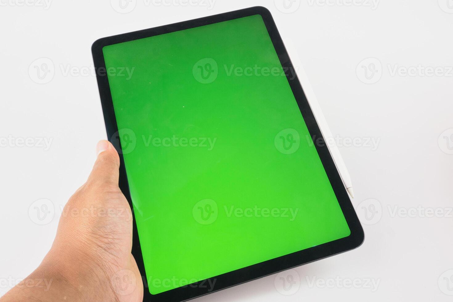 Hand Holding Modern Tablet with Green Screen Display and Stylus Attached photo