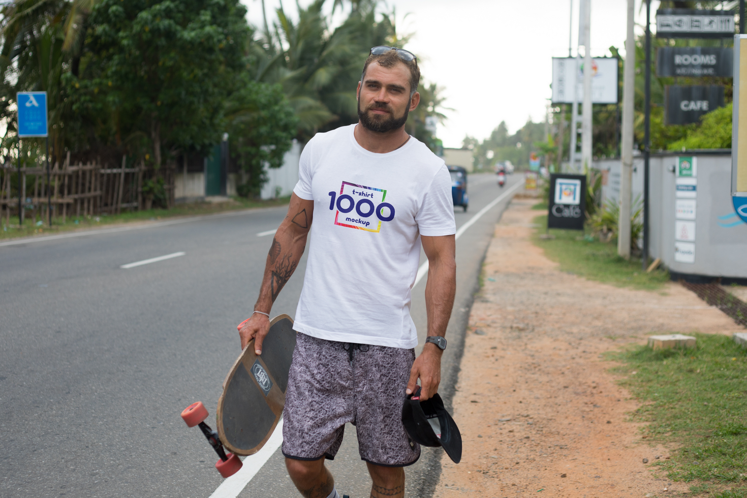 Young Man with Skateboard Walking Down Street in Tropical Location psd