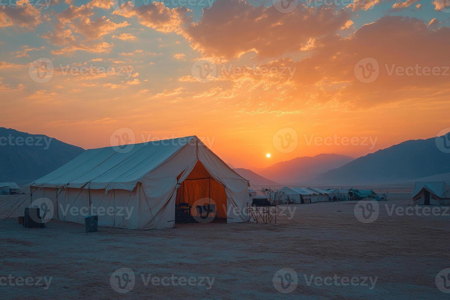 Desert glamping camp at sunrise with colorful sky and mountains photo