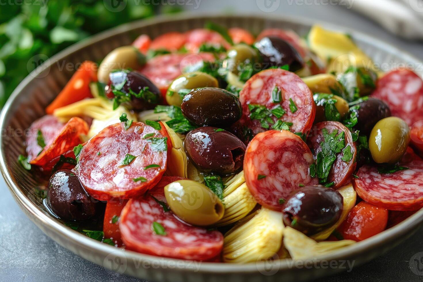 Sliced sausage with artichokes and olives composing a delicious mediterranean salad photo