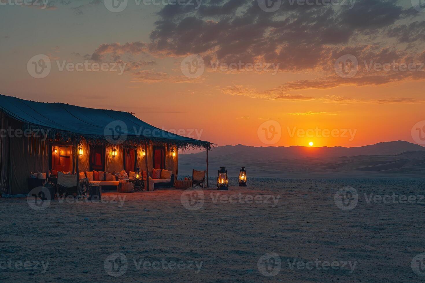 Desert glamping tent illuminated at sunset with lanterns photo