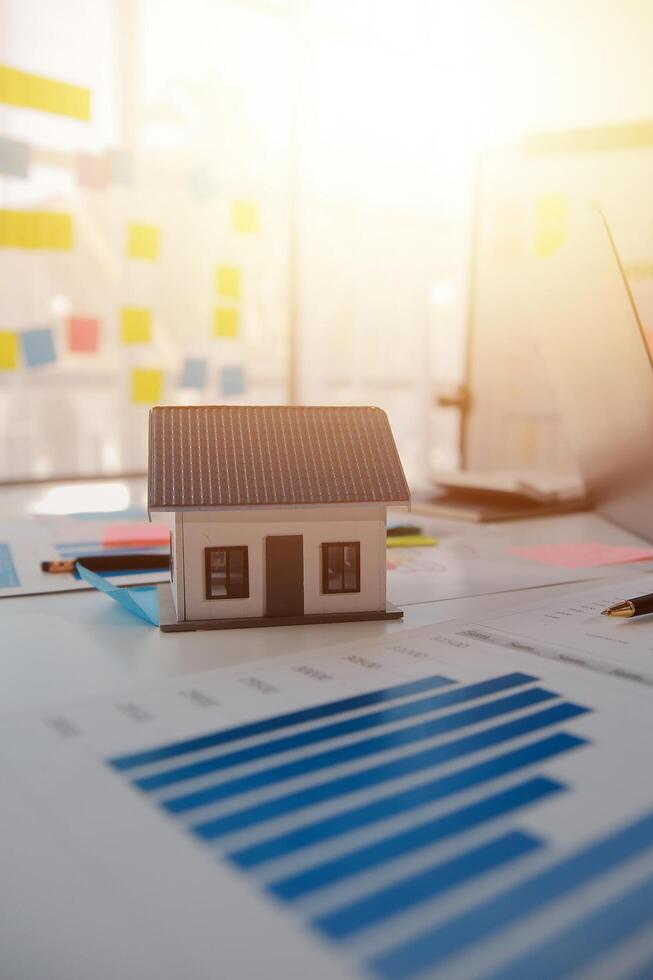 House model on desk with graphs and papers photo