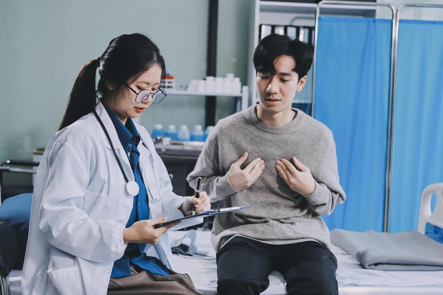 Asian doctor talking to patient in hospital bed photo