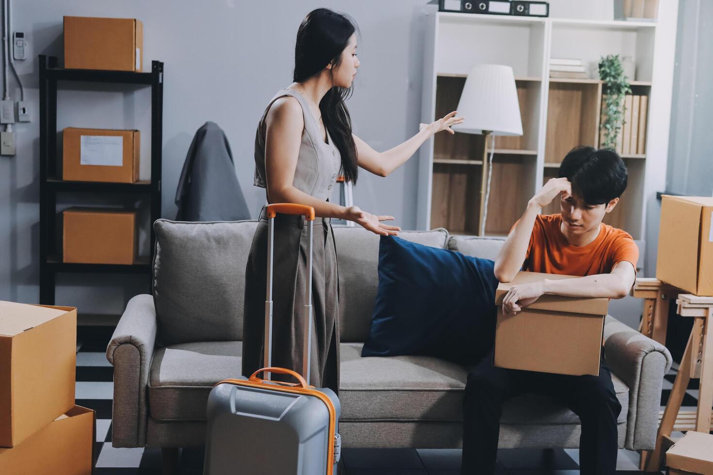 A man and woman are sitting on a couch with boxes around them photo