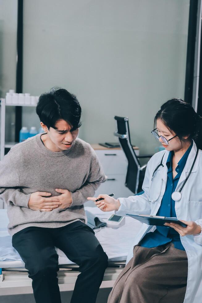 Asian doctor examining patient's stomach photo