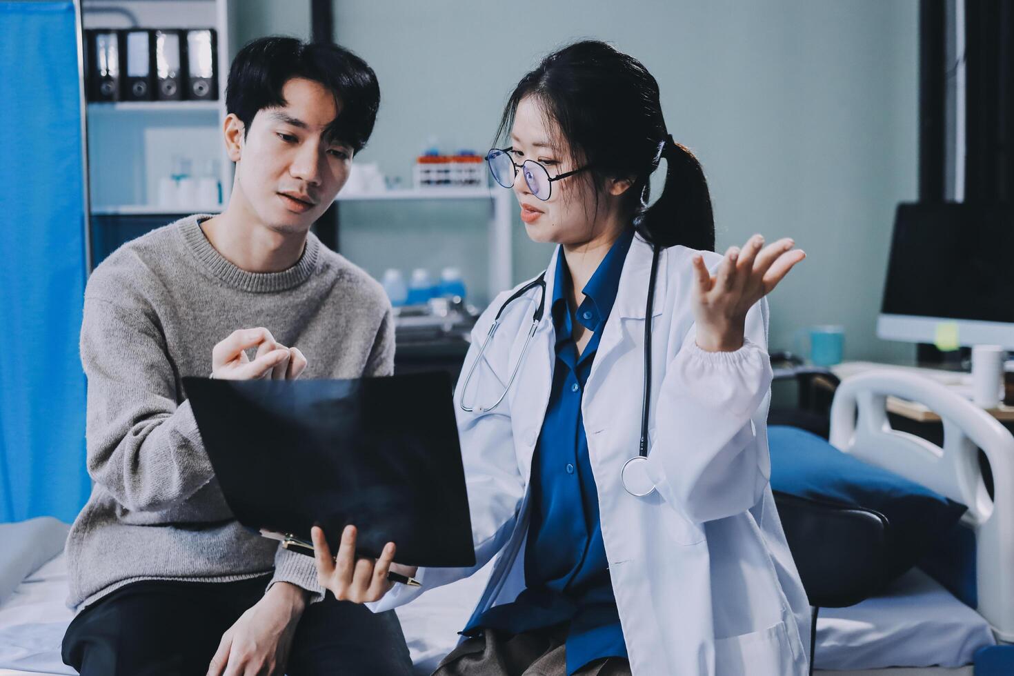 Asian doctor and patient discussing about medical condition photo